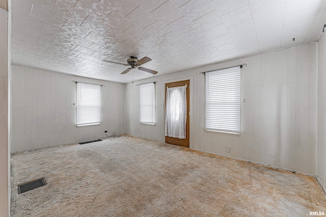 spare room with light colored carpet and ceiling fan