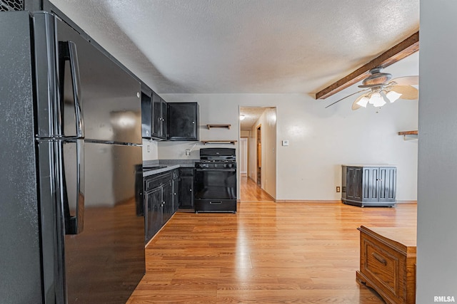 kitchen with light wood-type flooring, ceiling fan, black appliances, a textured ceiling, and beam ceiling