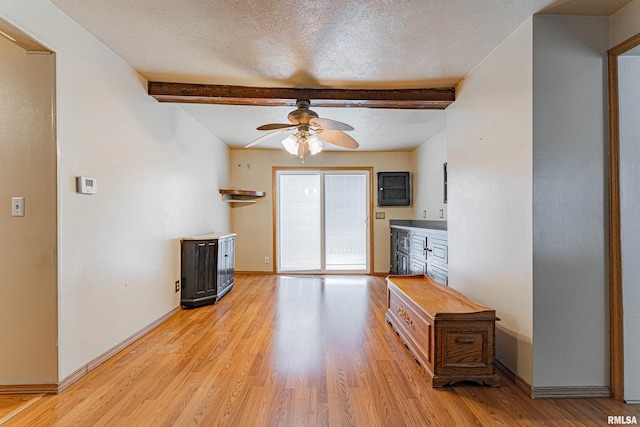 kitchen featuring ceiling fan, beam ceiling, a textured ceiling, and light wood-type flooring