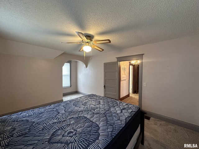 carpeted bedroom with ceiling fan and a textured ceiling