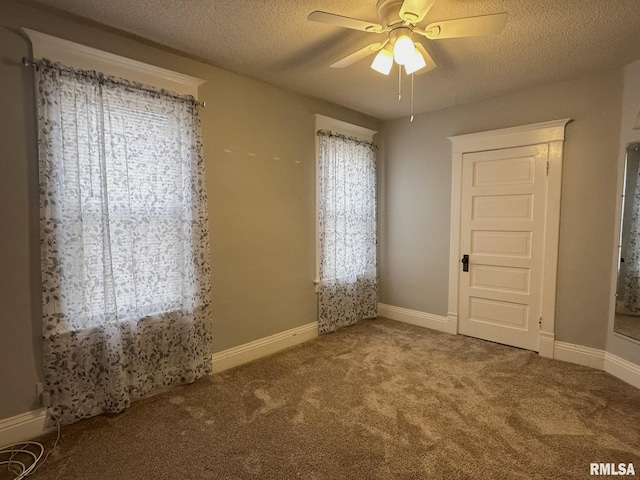 unfurnished bedroom featuring ceiling fan, a textured ceiling, and carpet