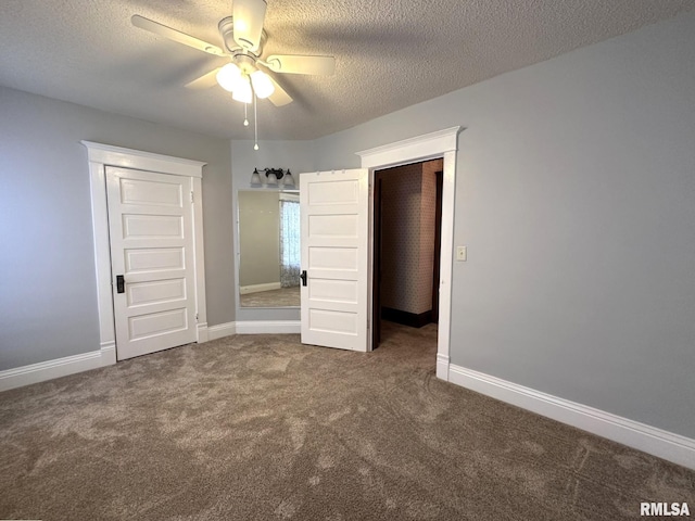 unfurnished bedroom featuring dark colored carpet, ceiling fan, and a textured ceiling