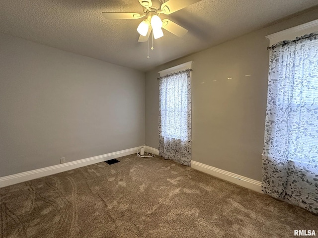 empty room with ceiling fan, a textured ceiling, and carpet