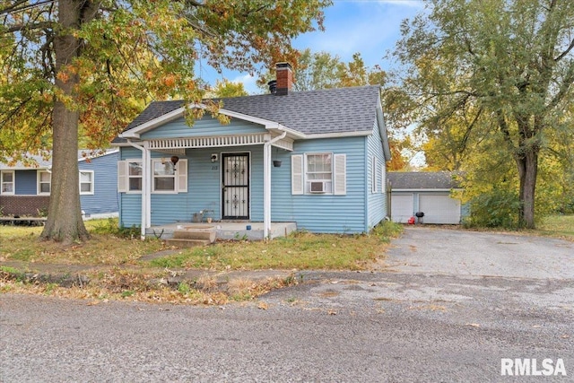 bungalow with an outbuilding, a porch, and a garage