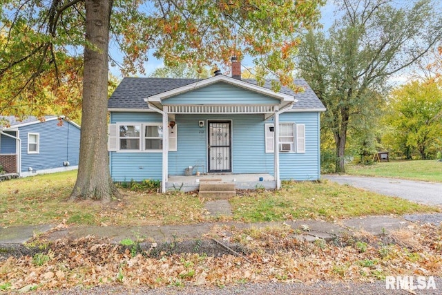 bungalow with a porch and cooling unit