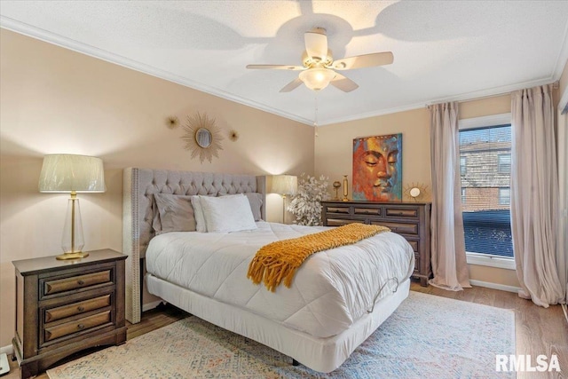 bedroom with hardwood / wood-style flooring, crown molding, and ceiling fan