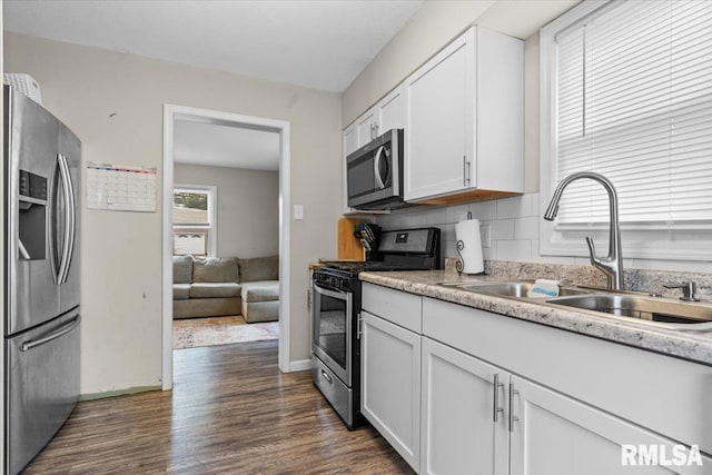 kitchen with white cabinetry, appliances with stainless steel finishes, dark hardwood / wood-style floors, and sink