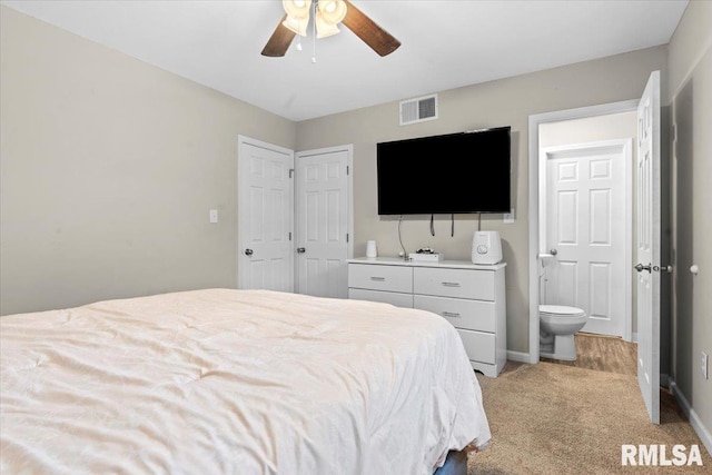 bedroom with ceiling fan, light colored carpet, and connected bathroom