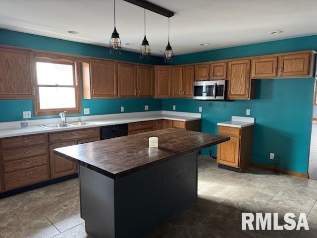 kitchen featuring decorative light fixtures, dishwasher, sink, and a kitchen island