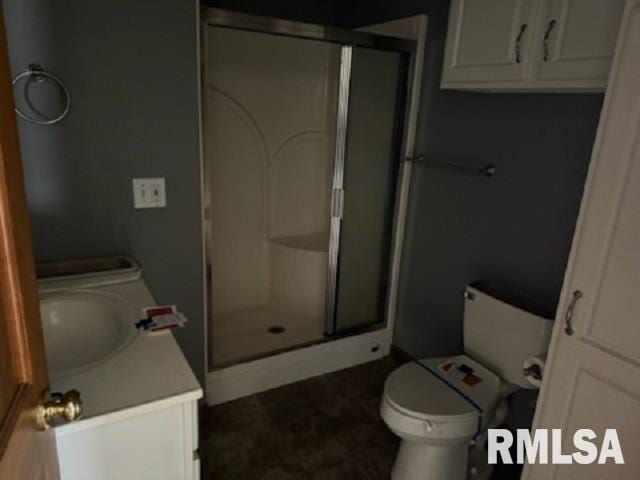 bathroom featuring vanity, toilet, and a shower with door