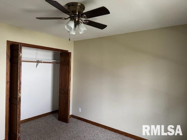 unfurnished bedroom featuring a closet, ceiling fan, and dark colored carpet