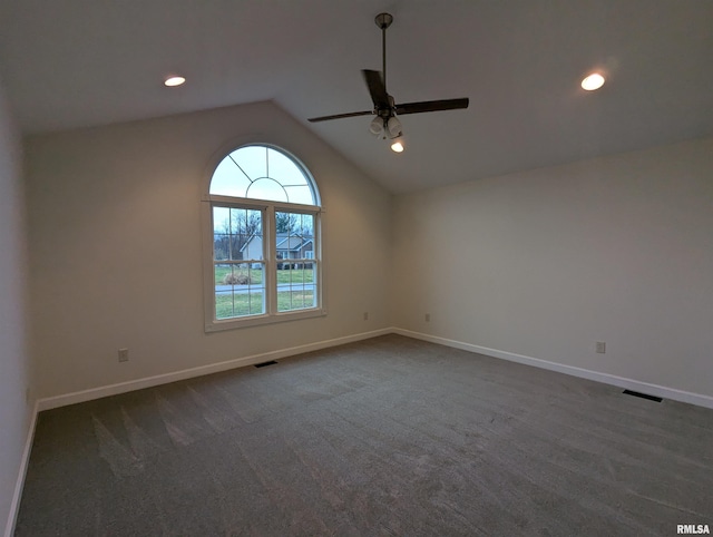 carpeted empty room with vaulted ceiling and ceiling fan