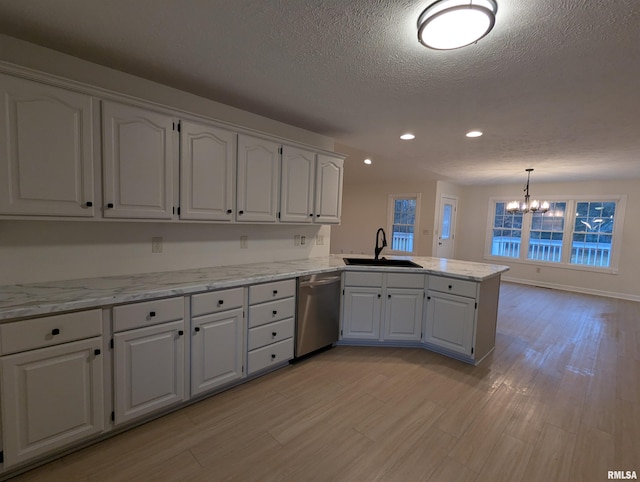 kitchen with sink, dishwasher, hanging light fixtures, white cabinets, and kitchen peninsula