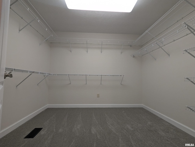 spacious closet featuring dark colored carpet