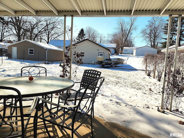 snow covered patio with an outbuilding