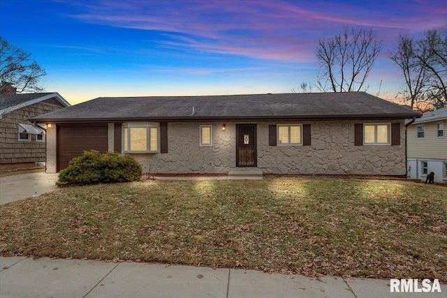 ranch-style house with a garage and a yard