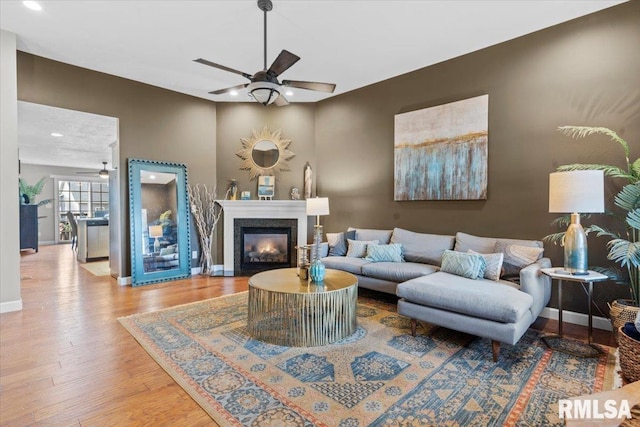 living room with light hardwood / wood-style floors and ceiling fan