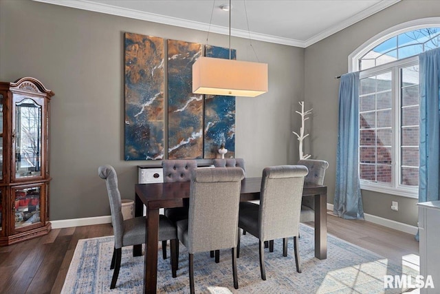 dining space with hardwood / wood-style flooring and crown molding