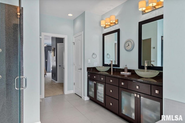 bathroom with tile patterned flooring, vanity, and walk in shower