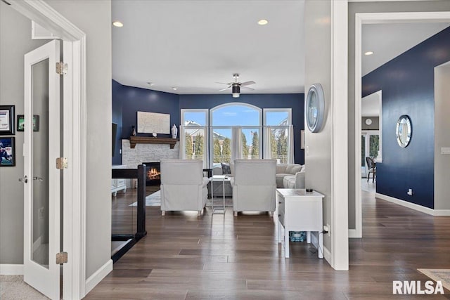 interior space with dark hardwood / wood-style flooring, ceiling fan, and a fireplace