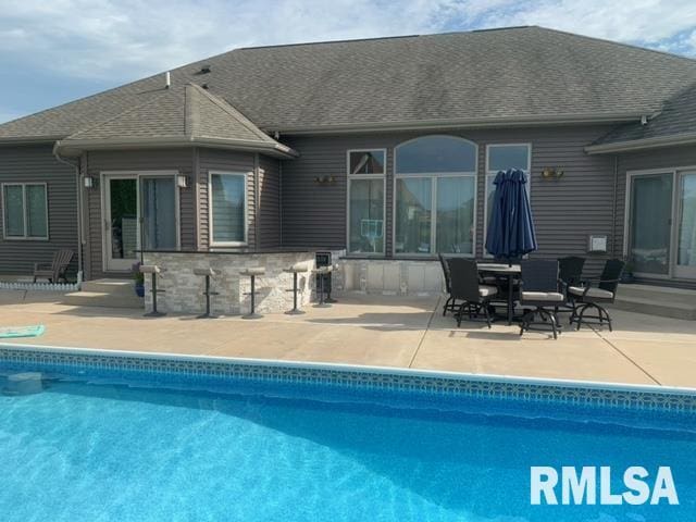 back of house with an outdoor bar and a patio area