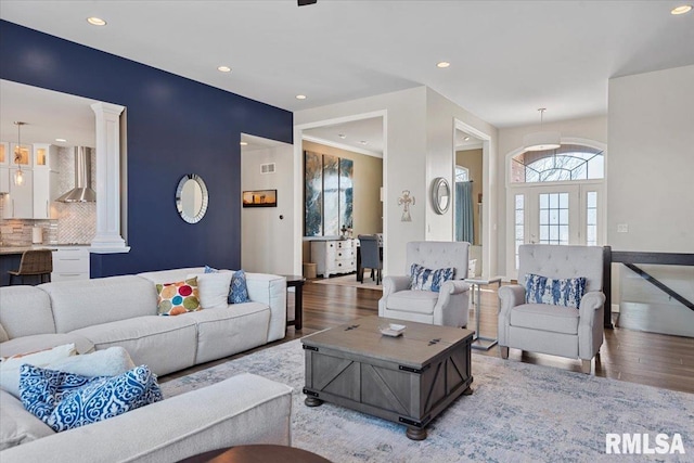 living room with ornate columns and hardwood / wood-style floors