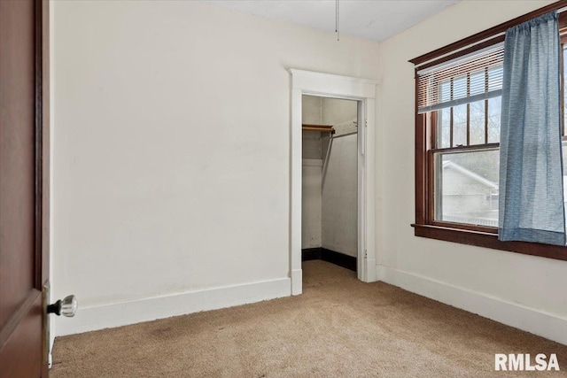 unfurnished bedroom with light carpet and a closet