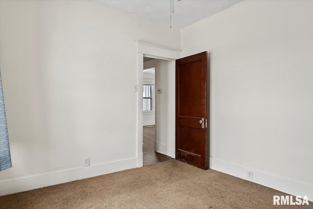 unfurnished room featuring dark carpet