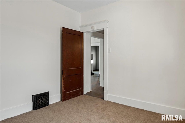 unfurnished room featuring dark carpet