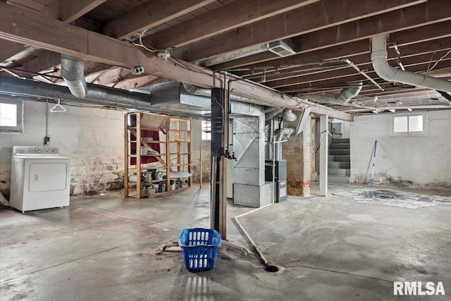 basement with a healthy amount of sunlight, washer / dryer, and heating unit