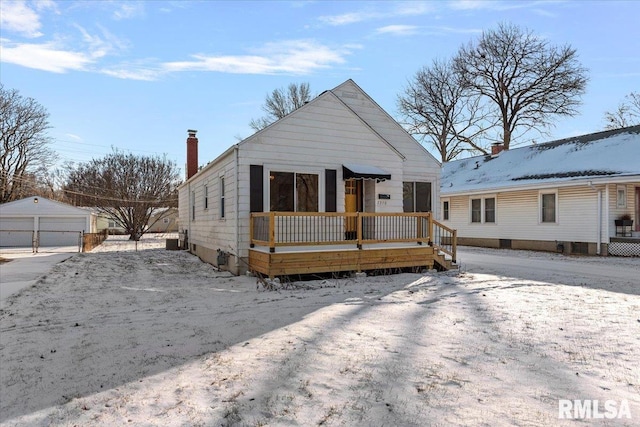 bungalow-style house with a garage and an outdoor structure