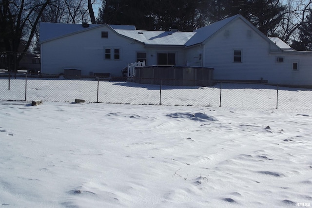 view of snow covered rear of property