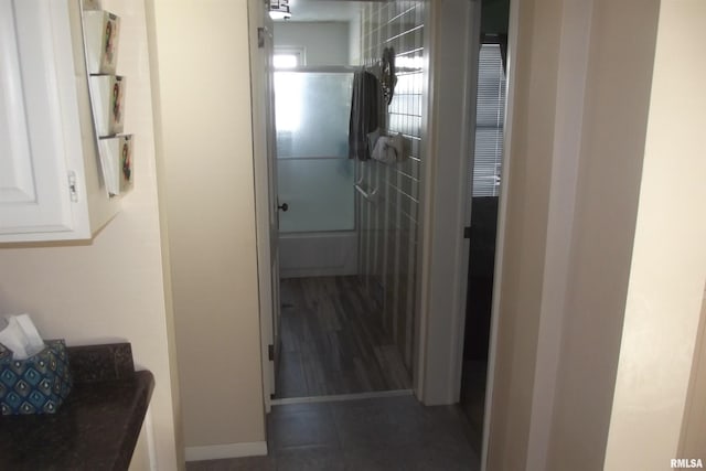 hall with dark tile patterned flooring