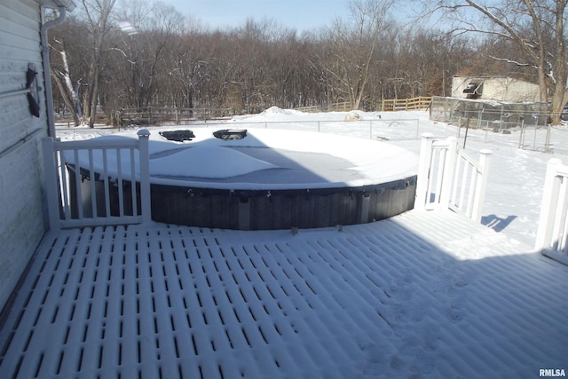 snow covered deck with fence and a hot tub