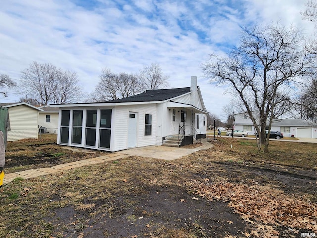 rear view of property featuring a patio area and a sunroom