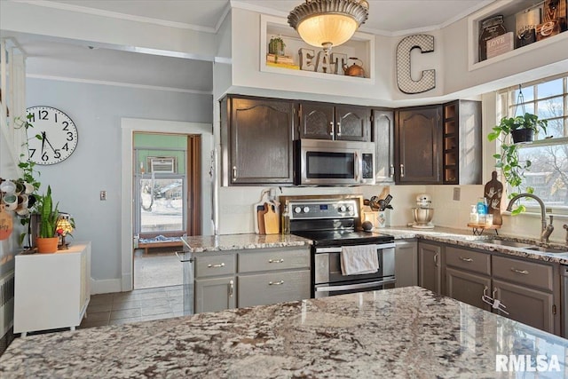 kitchen with sink, light stone counters, crown molding, dark brown cabinets, and stainless steel appliances