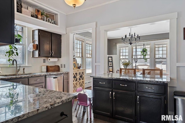 kitchen featuring sink, hanging light fixtures, dark brown cabinetry, ornamental molding, and stainless steel dishwasher