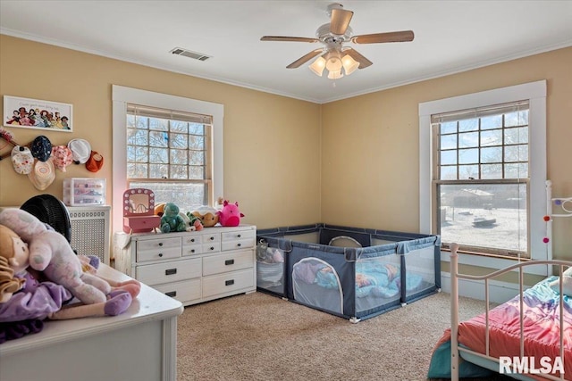 carpeted bedroom featuring multiple windows, ornamental molding, and ceiling fan