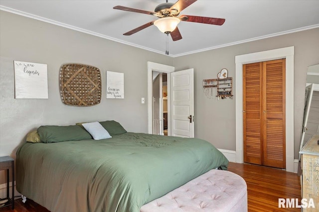 bedroom featuring hardwood / wood-style flooring, crown molding, ceiling fan, and a closet