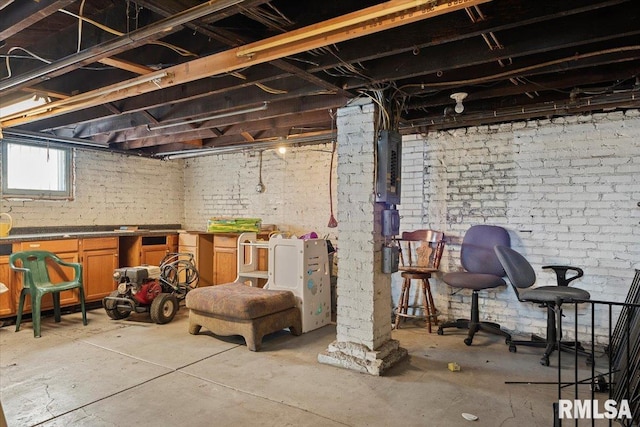 basement featuring brick wall and electric panel