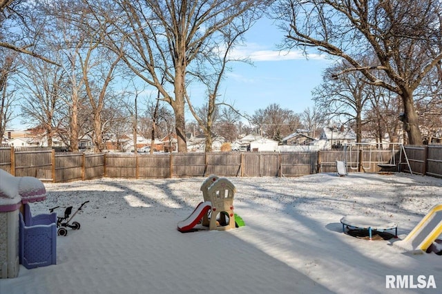 yard layered in snow featuring a playground