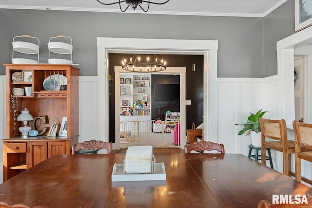 dining space with crown molding and a chandelier