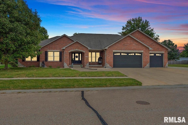 view of front of house with a garage and a lawn