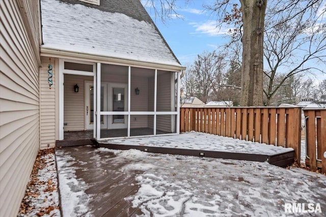 snow covered deck featuring a sunroom