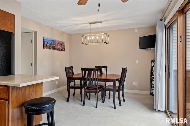 dining area with a textured ceiling and ceiling fan