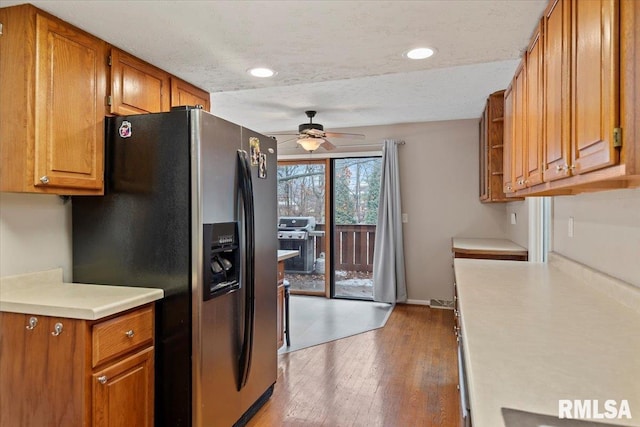 kitchen featuring ceiling fan, hardwood / wood-style floors, stainless steel fridge, and a textured ceiling