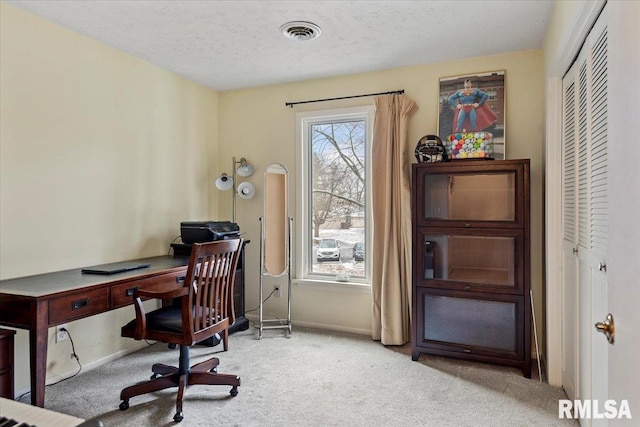 carpeted office featuring a textured ceiling