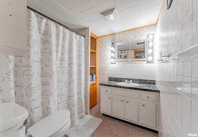 bathroom featuring tile walls, vanity, crown molding, and toilet