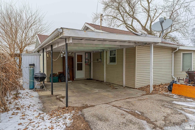 view of snow covered exterior featuring a carport