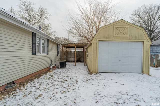 snow covered garage featuring central AC